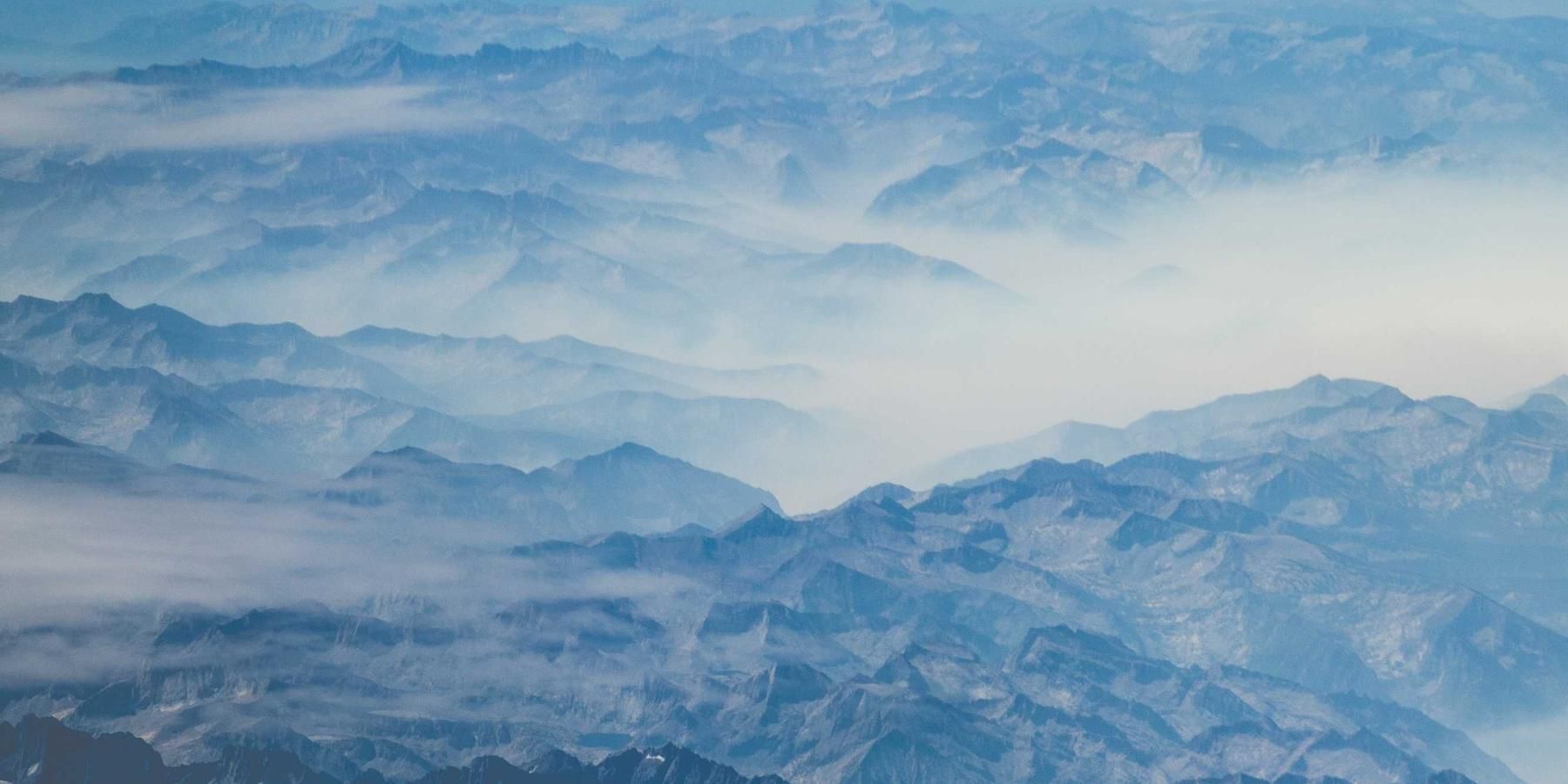 A mountain road disappearing into morning fog